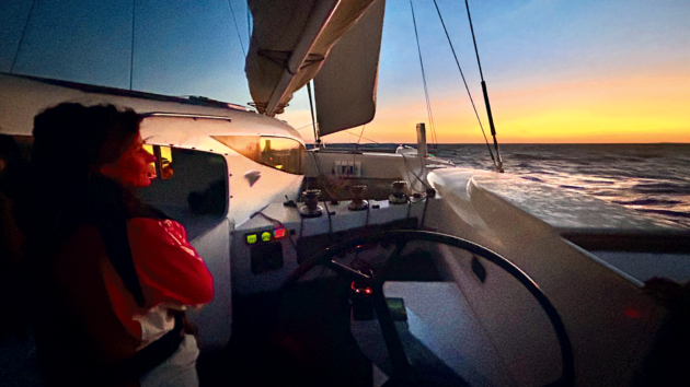 Ocean sailing at dusk aboard the author’s liveaboard performance cat